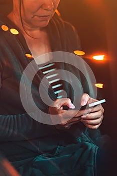 Woman texting on mobile phone in car at night