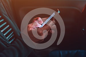 Woman texting on mobile phone in car at night