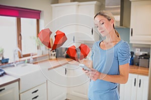 Woman texting on mobile phone with digital generated red hearts