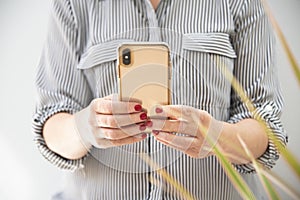 Woman texting on a smartphone in a home setting