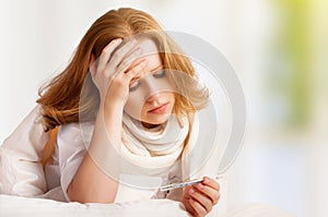 Woman with thermometer sick colds, flu, fever, headache in bed