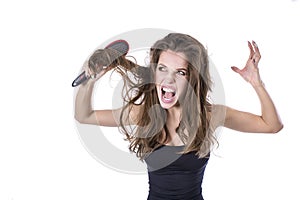 Woman with thick brown tangled hair try to comb hairs but fail. hair healt concept.