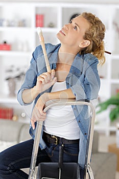 Woman thinking how to paint ceiling