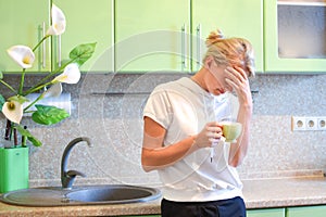 Woman thinking in the kitchen at home, family problems