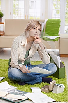 Woman thinking with paper in hand