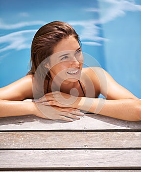 Woman, thinking and relax on vacation in swimming pool and smile on deck with happiness at hotel. Planning, holiday and