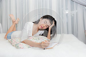 Woman thinking or stress and note down on paper.