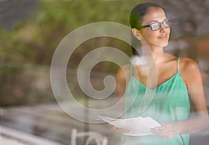 Woman, thinking at window and documents for review, glasses for reading with editor and fact check article. Inspiration