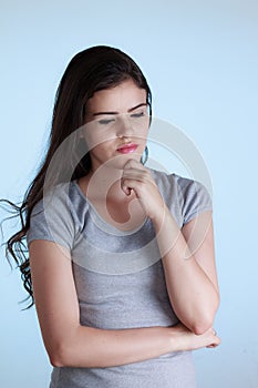 Woman with thoughtful expression and hand on chin