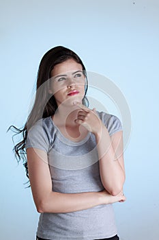 Woman with thoughtful expression and hand on chin