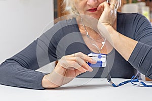 Woman thoughtfully looks at the results of measuring the heart pulse