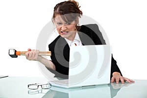 Woman threatening computer with hammer photo