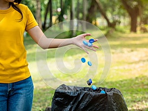 The woman threw the bottle cap after use into the trash prepared for storage for recycling and reuse