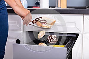 Woman Throwing Food In Trash Bin photo