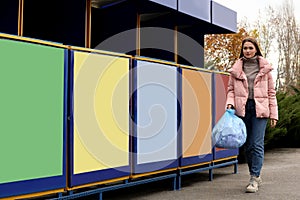 Woman throwing garbage at recycling point outdoors