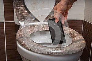 Woman throwing mobile phone in the toilet bowl