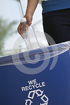 Woman Throwing Plastic Bottle In Dustbin photo