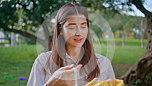 Woman throwing plastic bottle in recycling bag at park closeup. Eco volunteer