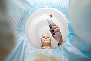 woman throwing toothbrush into trash can photo