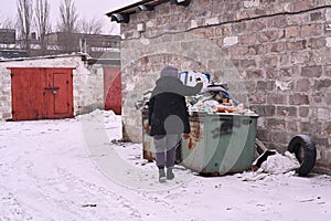 A woman throws garbage into an overflowing trash can
