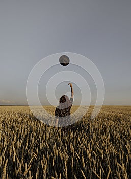 Woman throws her hat Happy woman enjoying the life in the sunny field. Nature beauty, white clouds and field with golden