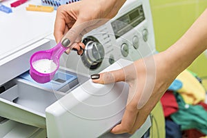 Woman throws laundry detergent into the washing machine.