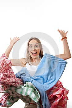 Woman throws a pile of clothes, isolated on white