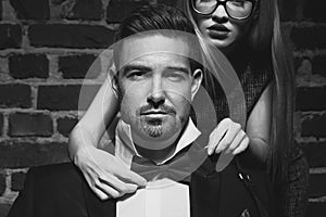 Woman tie bow for sexy man in tuxedo black and white