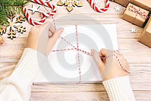 Woman tie Christmas letters in envelope, children santa claus letter in envelope, christmas background. Toned