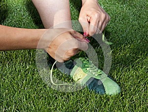 Woman ties laces on sport shoes