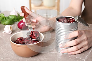 Woman with tin can of conserved beans