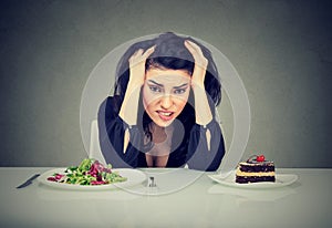 Una mujer cansado de decidir sobre sobre el comer saludable comida o pastel ella es un deseo 