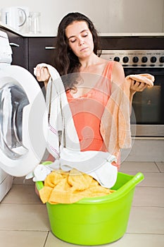 Woman tired and washing clothes in machine