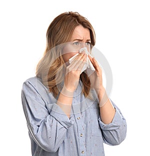 Woman with tissue suffering from runny nose on white background