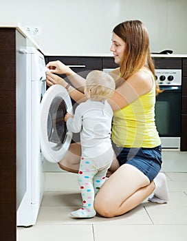 Woman with toddler using washing machine