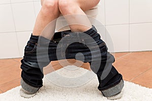 Woman on the toilet is suffering about congestion photo