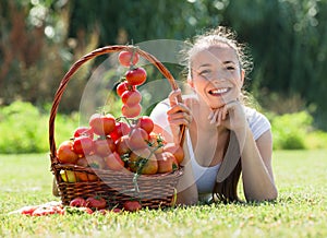 Woman with tomato harvest in garden