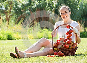 Woman with tomato harvest in garden