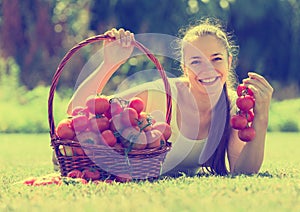 Woman with tomato harvest in garden