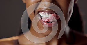 Woman, tongue and mouth with licking lips in closeup for dental care, oral hygiene and orthodontics in studio. Female