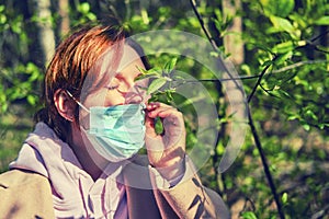 A woman took off her medical mask after being quarantined near a tree with green leaves