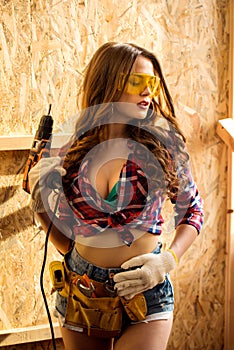 woman with tool belt and electric drill posing