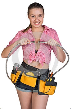 Woman in tool belt holding flexible tap hose