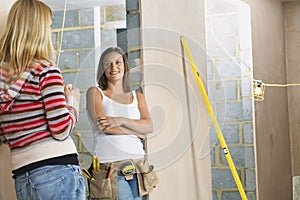 Woman With Toolbelt Talking To Friend photo