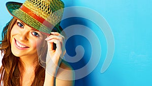 Woman with toothy smile touching hat