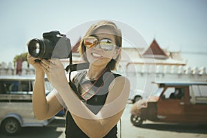 woman toothy smiling with happiness holding dslr camera standing in ayutthaya thailand