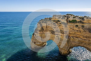 A woman on the top of cliffs at Marinha Beach in Algarve, Portugal