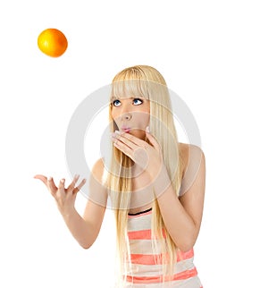 Woman tossing up an orange