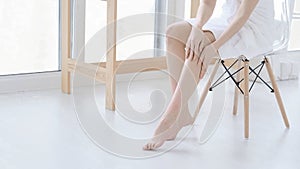 woman touch her smooth and soft skin on legs, enjoy beauty procedures. young asian woman applying cream and lotion touch