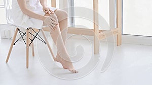 woman touch her smooth and soft skin on legs, enjoy beauty procedures. young asian woman applying cream and lotion touch